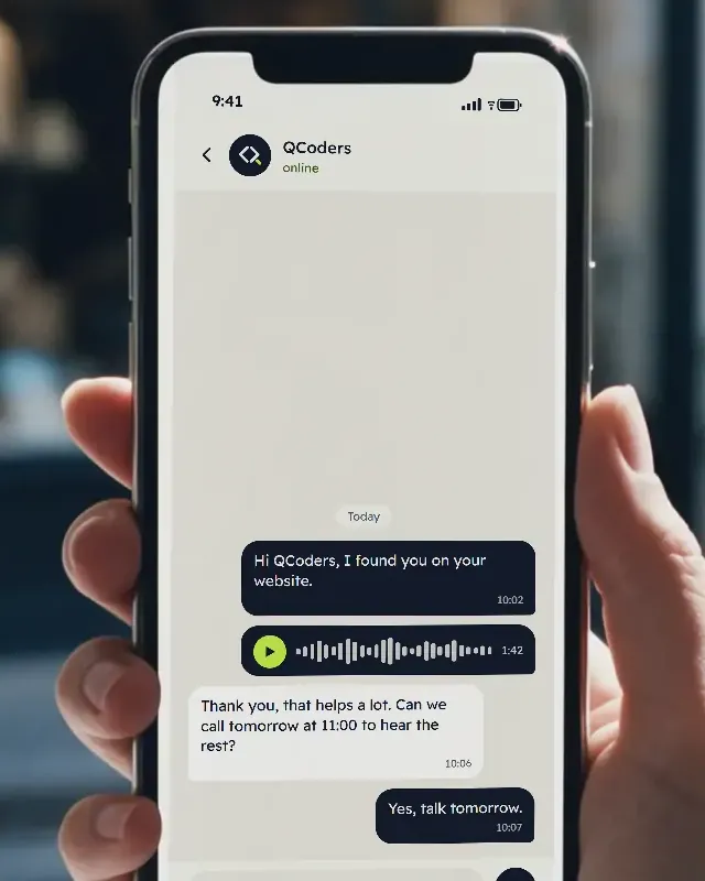 Close up of a phone in a hand: a first message to Qcoders, a voice note, and the reply asking to call tomorrow at 11:00 to hear the rest